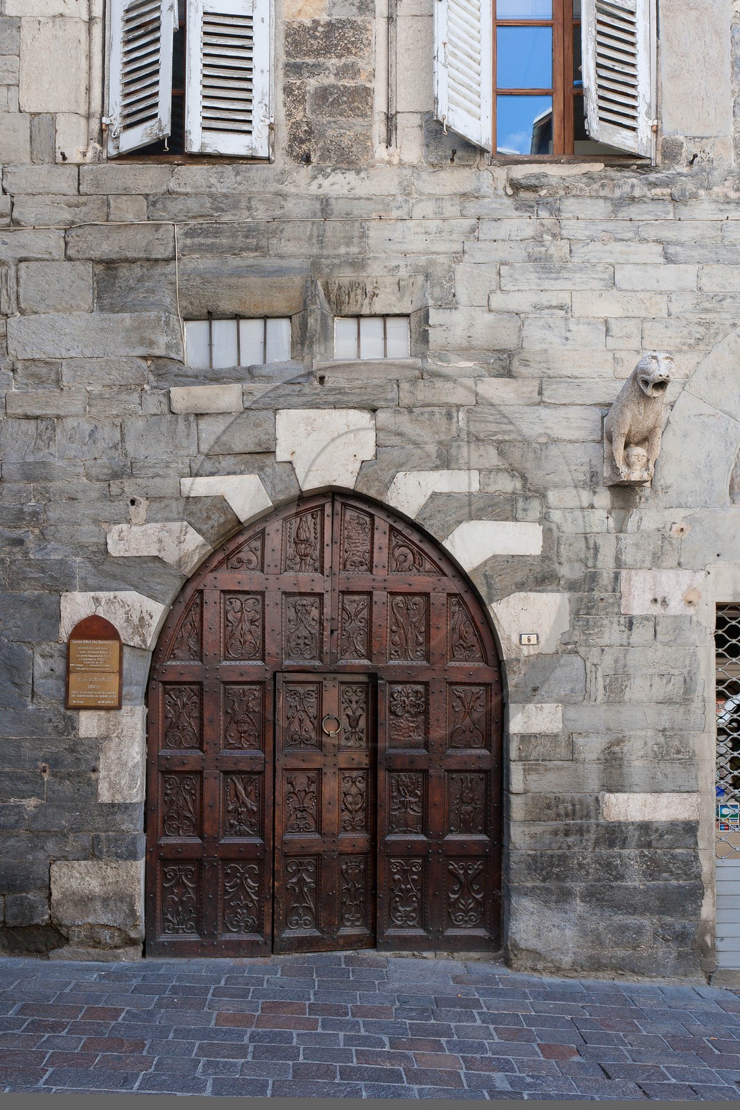 Embrun, Maison des Gouverneurs, Porte Renaissance accostée d'un lion à mi-corps tenant dans ses pattes une tête humaine